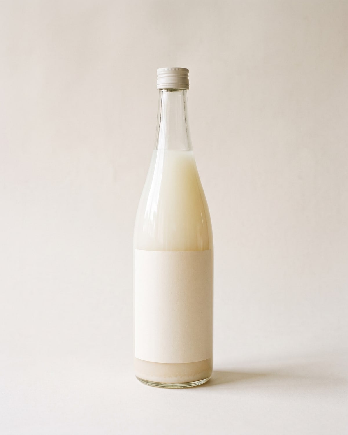 A 720ml bottle of cloudy white nigori sake with sediment settled at the base