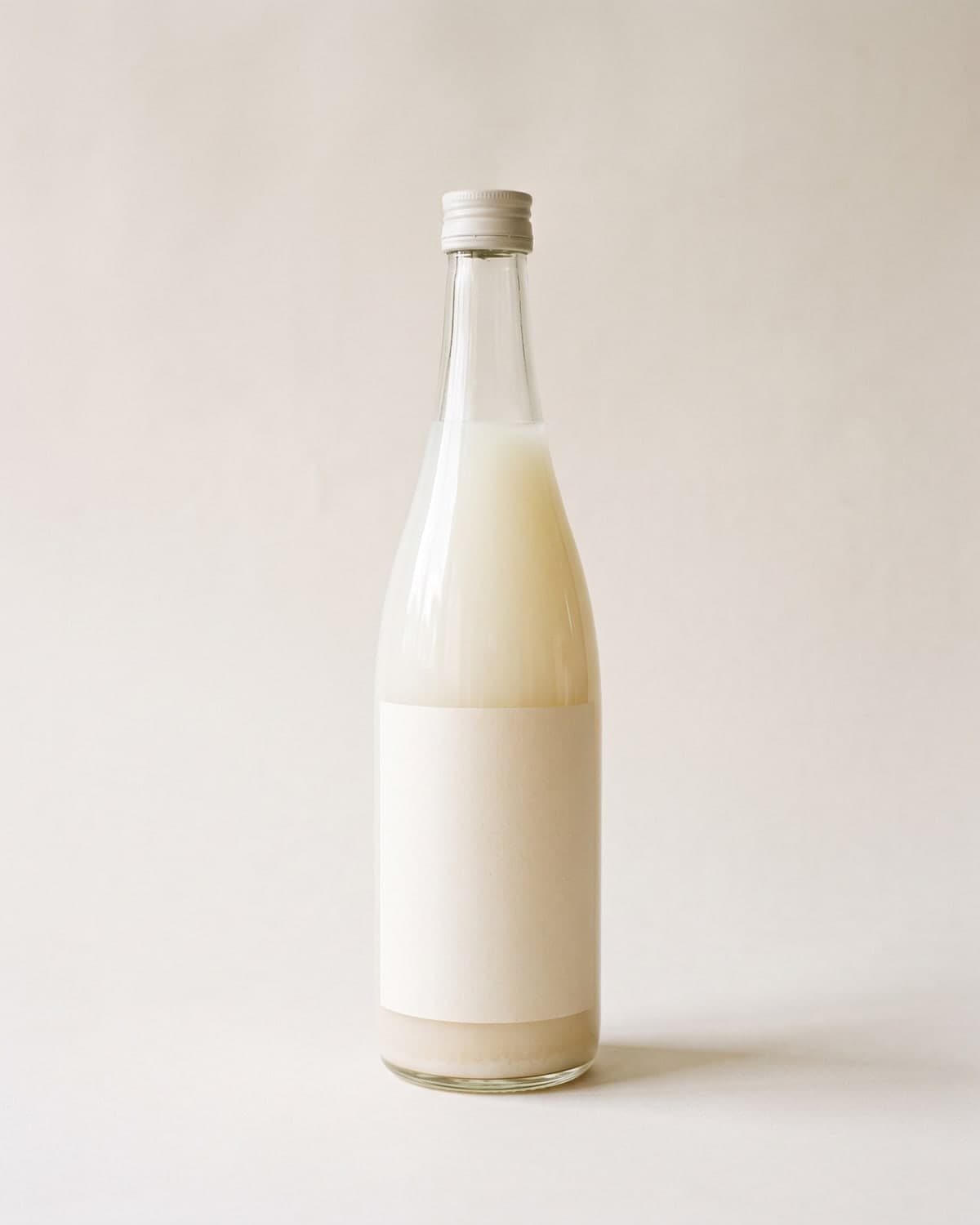 A 720ml bottle of cloudy white nigori sake with sediment settled at the base