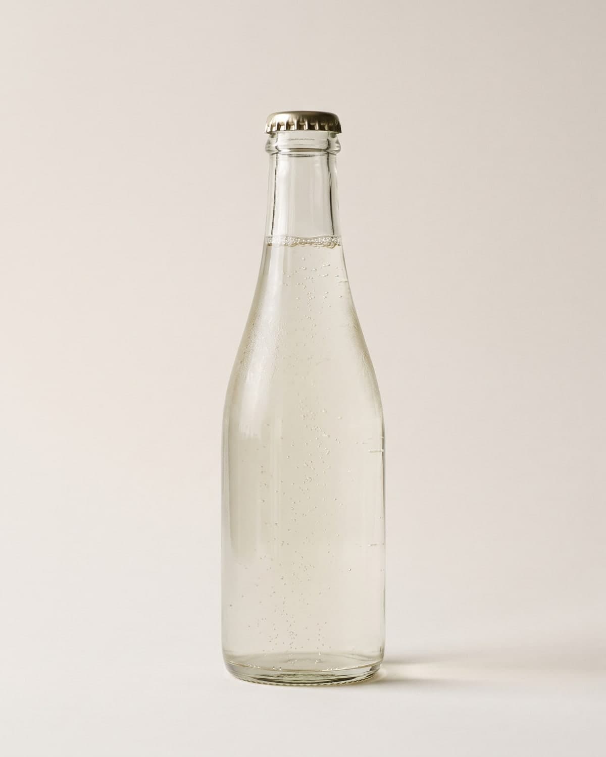 A 300ml crown-capped sparkling sake bottle with fine bubbles visible in the liquid